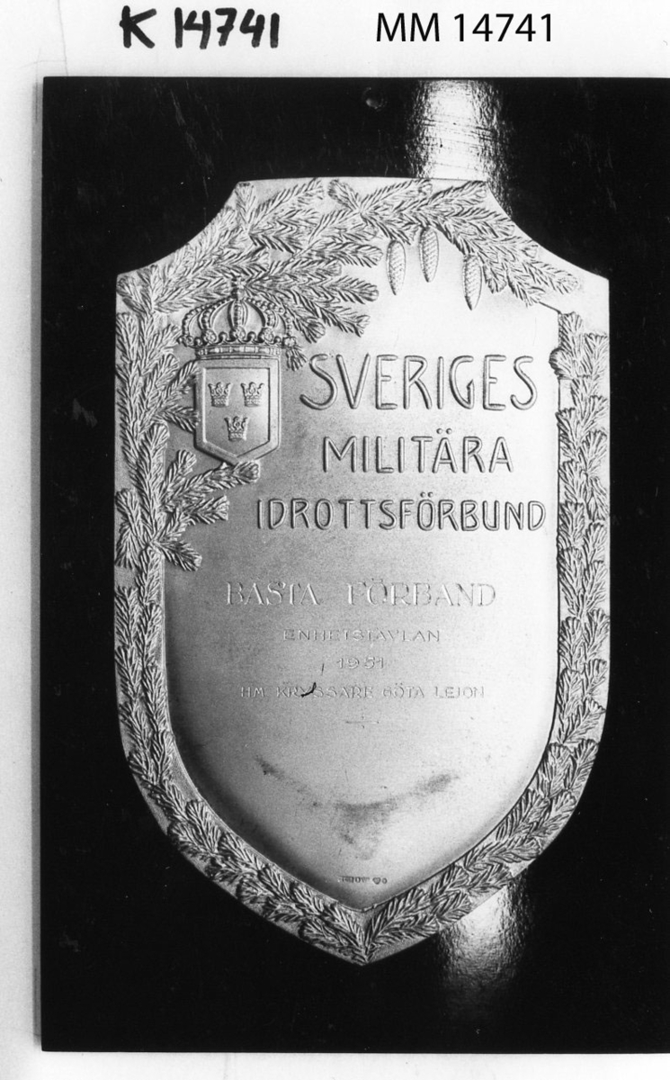 Plakett, idrottssköld i guld på platta av bakelit.
Ingravering: Bästa förband enhetstävlan 1951.
H.M. Kryssaren Göta Lejon.