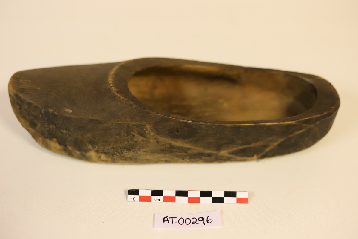 En høyre sko som er utskåret med kniv og pusset. Den er hulet ut med et spesialredskap. Det er boret et hull på høyresiden av skoen 0,5 cm under randen.