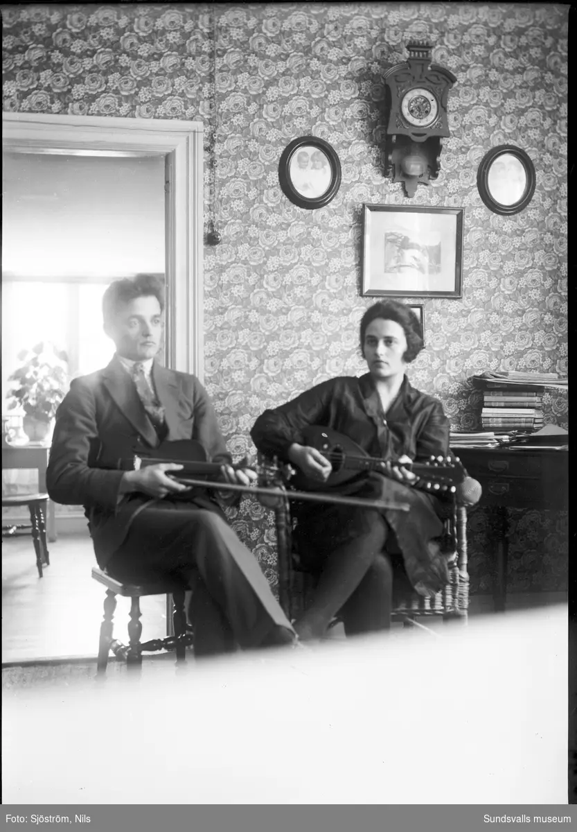Två av fotografen Nils sjöströms barn, tvillingarna Gösta och Ingeborg, med musikinstrument i händerna.