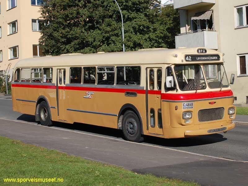 Buss med nr. 42 plassert i front. Bussen er i en lys brun farge i bunn og en kremhvit farge i øvre halvdel med et rødt bånd som skiller de to. 