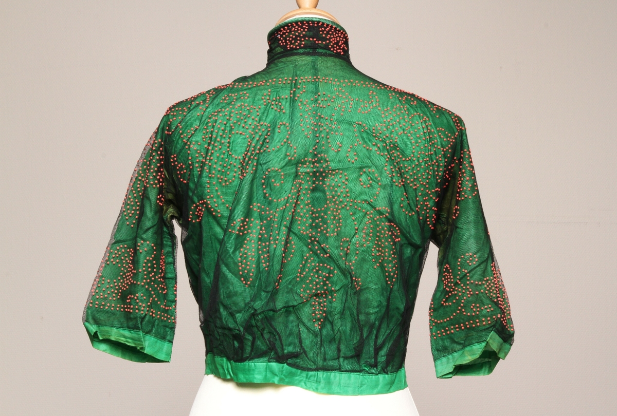Grønn bluse i silke med svart tyll med pålimt rødt mønster. 