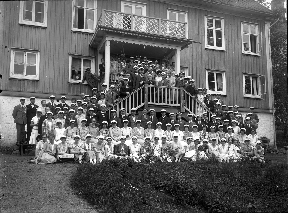 En mycket stor samling av kvinnliga och manliga studenter på baksidan av Gränna prästgård.