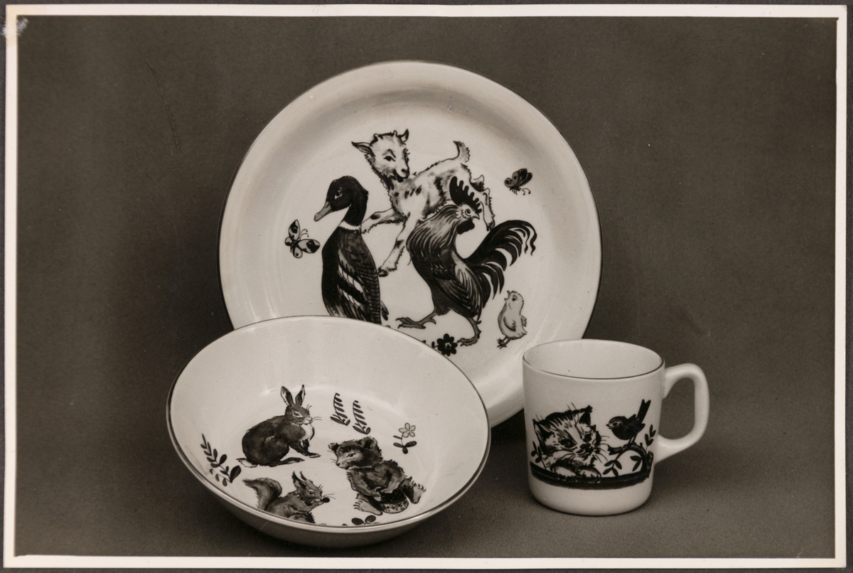 Barneserviset "Fauna" fra Stavangerflint A/S. Avbildet sett viser en tallerken, skål og kopp med ulike dyremotiv.
