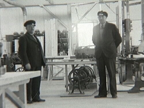 Interiör från snickerifabriken Varbergs Träförädling. Två män står bland maskinerna i centrum av bilden. Bild 2 visar männen i närbild.
