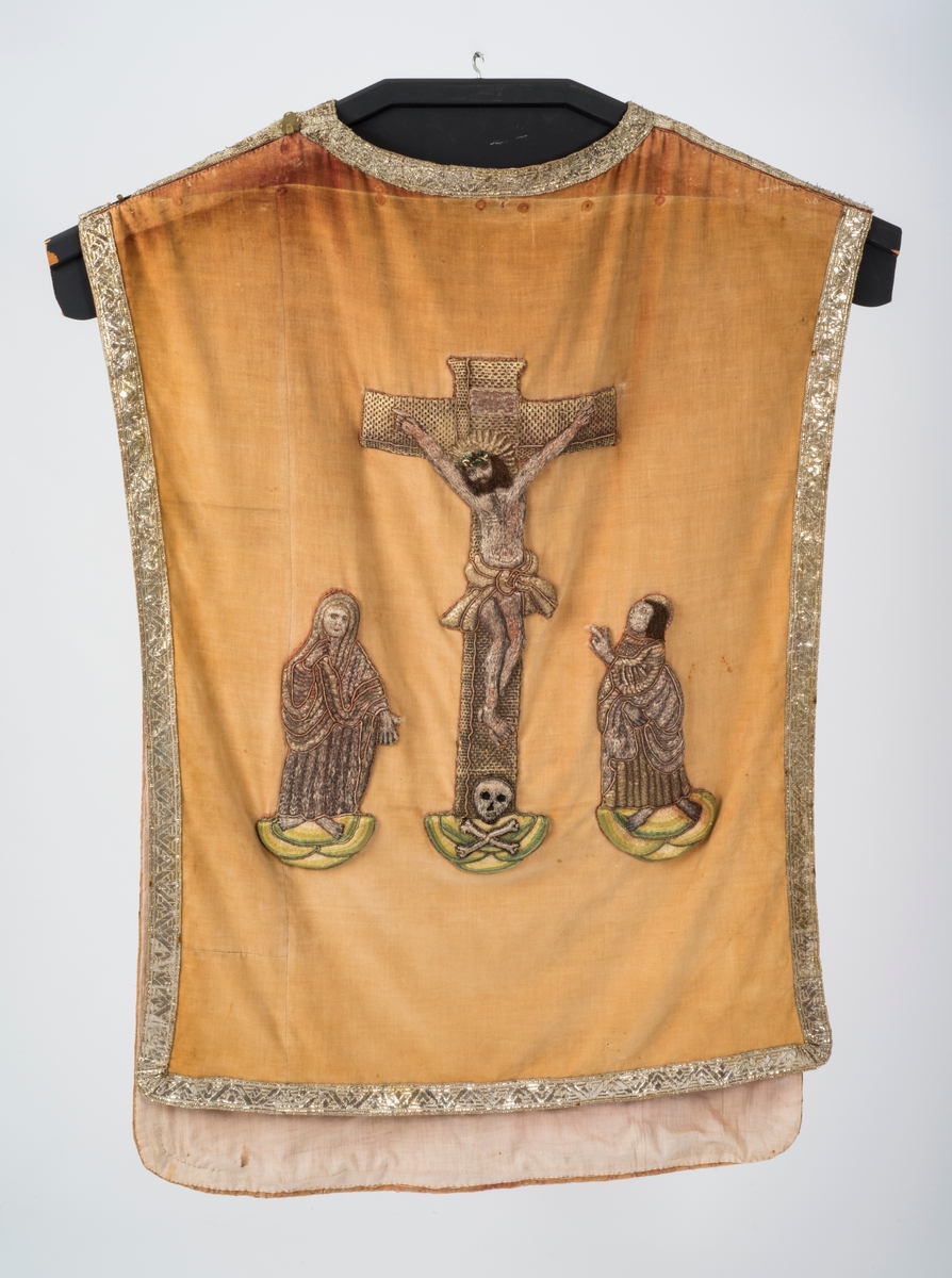 Bakside: Golgatascene med Jesus på korset, Maria ved hans høyre side og Johannes ved hans venstre. Ved korsets fot er det en hodeskalle med bein i kryss.