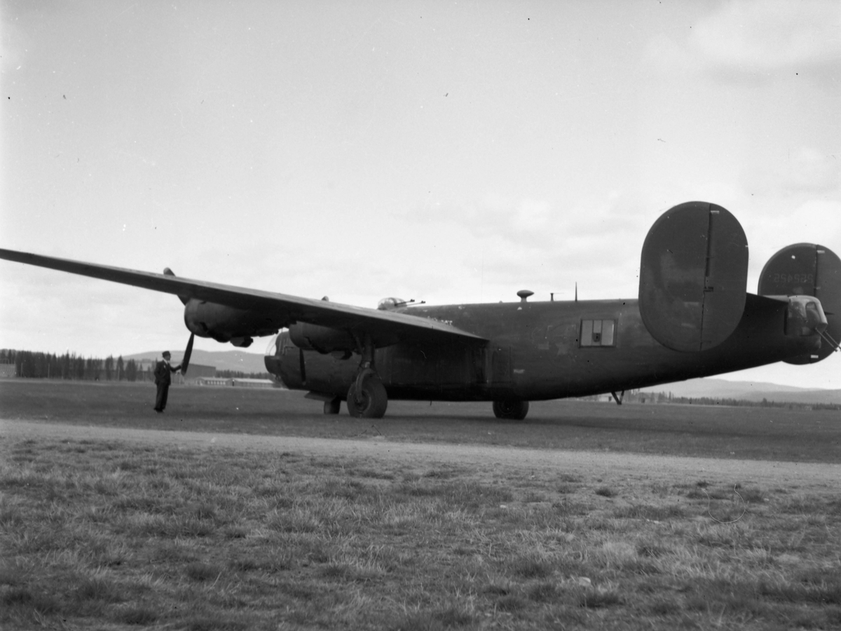 Et bombefly ved navn Consolidated B-24 Liberator. En mann i dress står og kjenner på propellen.