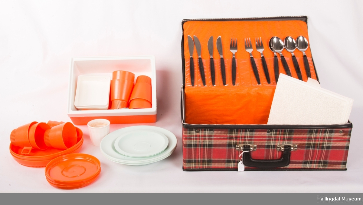 Picknikkoffert med bestikk, skåler, tallerker, plastglass, eggeglass, tekjeer, dype  tallerker, termoskopp, spisebestikk i stål, en boks med lokk.
