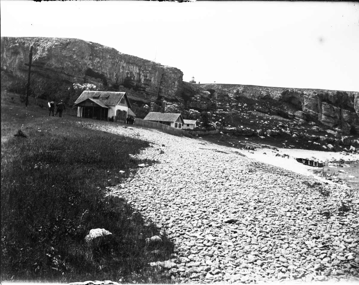 Havsstrand med klippa och byggnader, 23 juni 1901