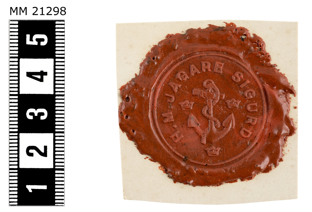 Sigillavtryck av rött lack på papper. I mitten stockankare omgivet av tre kronor Längs kanten text:  "H.M. Jagare Sigurd".