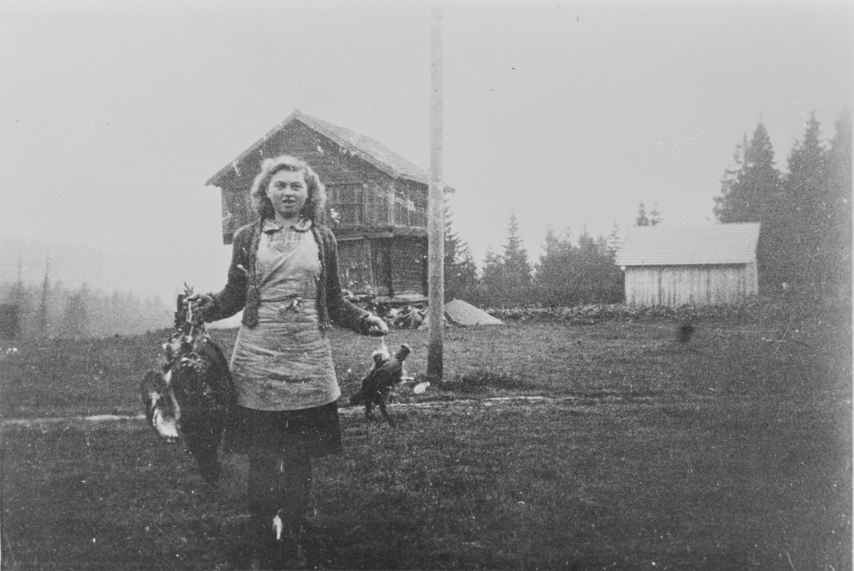 Jenny Haugen (Hunstad) holder jaktutbytte etter Erling Langeruds jakttur. På Langerud, ca. 1940.