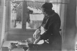Kristi Eidal ved oppvasken. På Skyliholdt, uten år.