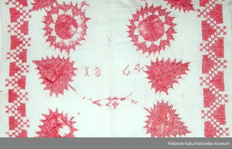 Hallandssöm. Mönster i rött, blekt. Märkning: "ASAD 1864". Troligen gjord av Anna Stina Andriasdotter, (antagandet gjord då det är samma märkning och liknande mönster som på föremål 43 983.)
