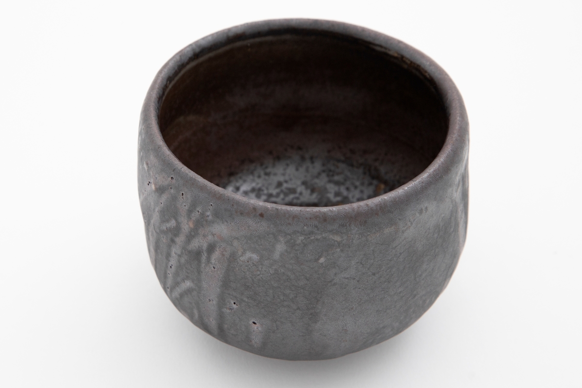 Asiatisk inspirert tebolle i dreid steingods, med et abstrakt stråaktig motiv under en blågrå glasur.