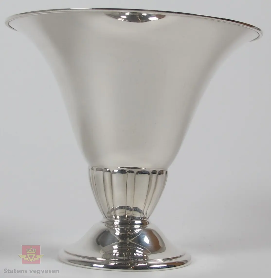Pokal i sølv formet som en vase/beger.
