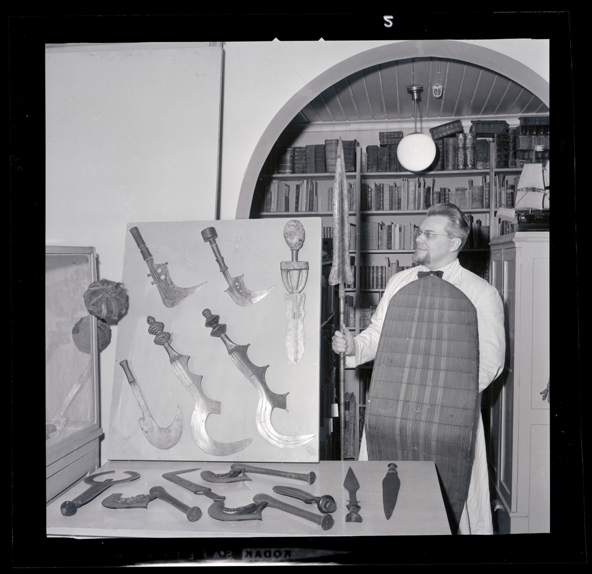 Ur handskrivna katalogen 1957-1958:
Yxa för kanottillverkning, Afrika.
L.41,5 cm; kraftigt träskaft m. cylindrisk träklump; skaftet virat m. järnband; svängd egg, m. 2 runda hål. Hel.
