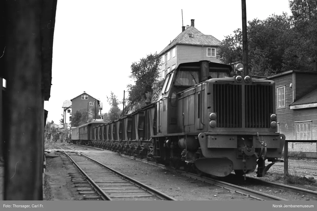 Sulitjelmabanens diesellokomotiv ODIN med blandet tog ved Furulund., mellom maler/snekkerverksted og blikkenslagerverksted/bilverksted