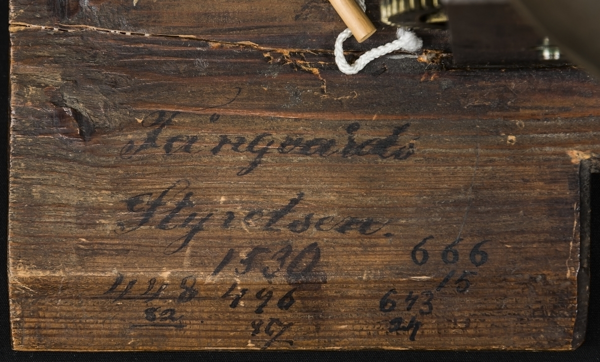 Träfoder, i vitt med guld. Tidigaste färglager i rött, blått o grönt.  Senare i brunt. 1700-tal. Urverket tillverkat av Johan Wasberg. (1696-1774) från Malmköping. Bakom urverket är det skrivet Fångvårdsstyrelsen.