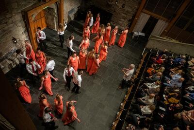 Bilde fra takhøyde ned på scena i Aulaen på Domkirkeodden der Defrost Youth Choir står og holder konsert.. Foto/Photo