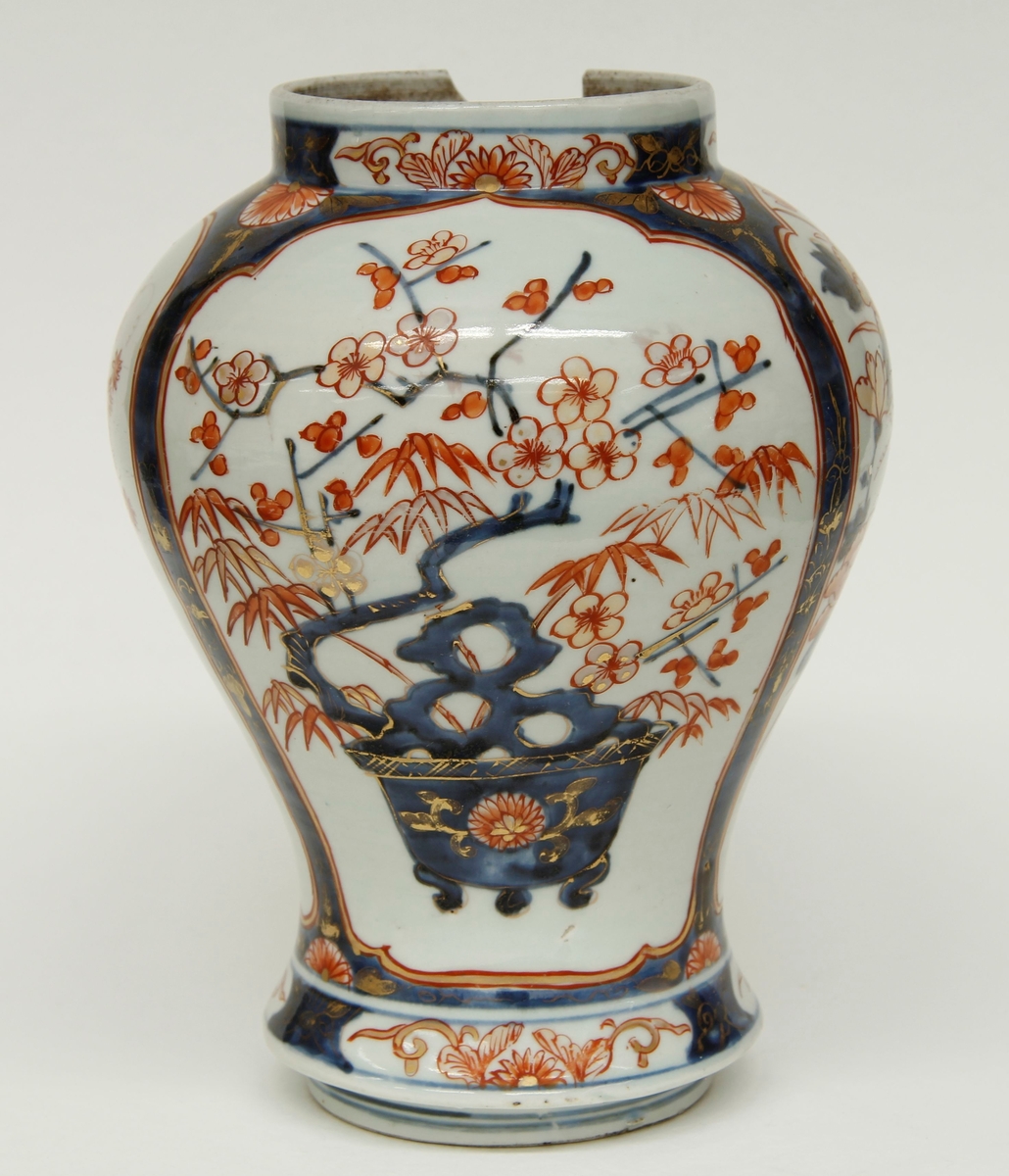 Balusterformet vase, kort, bred sylindrisk hals. Blomsterornamenter i blått og rødt med gullstaffering. Ingen produsentmerker.