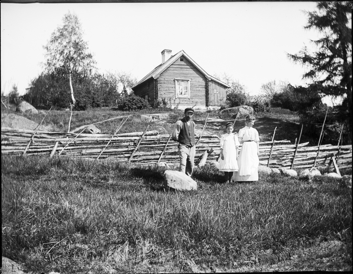 Familj vid gärdesgård, Uppland