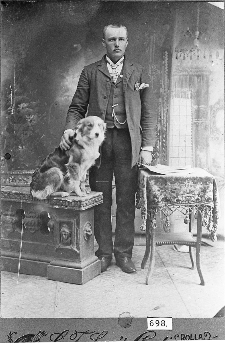 Knut E. Nelson med en hund. Atelierportrett, trolig rundt 1900.