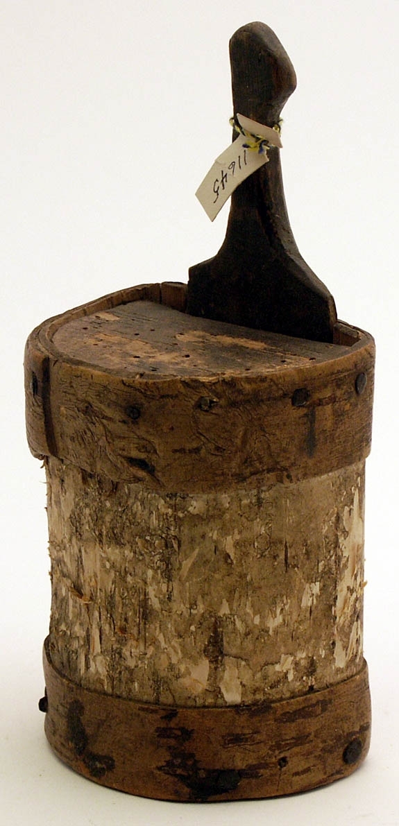 Ask, näverask av trä, utvändigt klädd med näver, i form av en längs ena sidan något avskuren cylinder. Försedd med skjutlock av trä med handtag.
