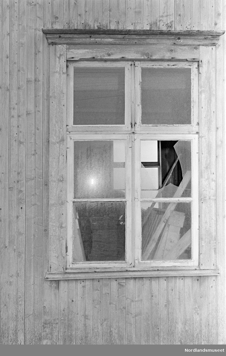 Butikken, Koppardal, etter skade ved sprenging. Inngangen. Dobbel dør av trepanel. Det var tidligere to vinduer øverst på dørene, men de er nå spikret igjen. Dørhandtak og lås av jern. Lys over døren. Et skilt på hver side av døren. Veggen rundt døren er av stående trepanel. En stor stein står til venstre for døren. Bilde 2 viser et vindu etter skade ved spenging. Sprosset vindu med trekarm rundt. En vindusrute er knust. Stående trepanel på veggen rundt vinduet. En del treplanker og et vindu på andre siden av huset, innenfor vinduet. Bilde 3 viser en dobbel dør av tre med to tidligere vinduer øverst som nå er spikret igjen. Dørhandtak av jern. Veggen rundt døren er av stående trepanel.