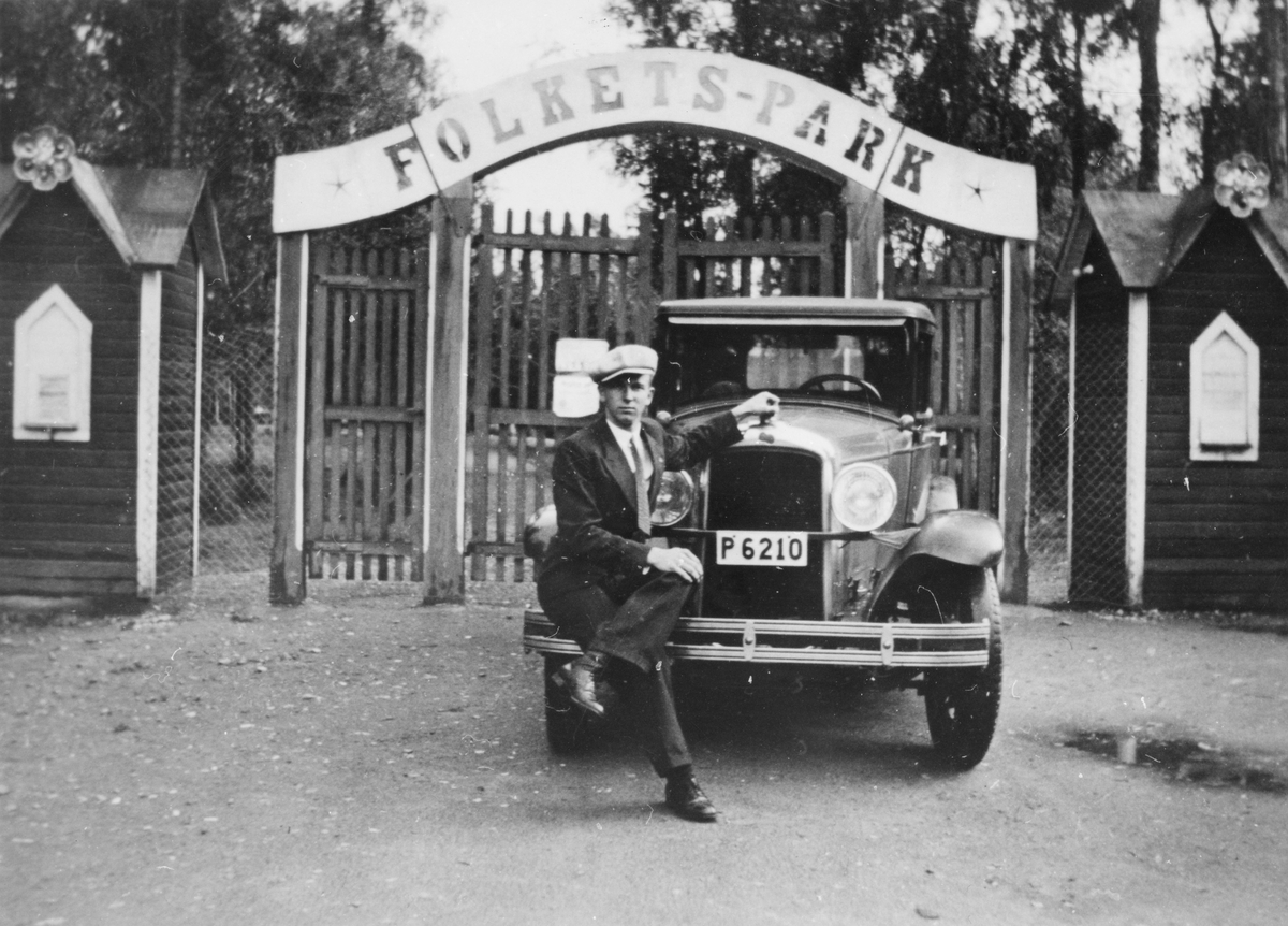 Vid bilen (Pontiac) sitter sonen Bertil Damm framför Folkets park. Ägaren till bilen var elektrikern Gustav Damm.