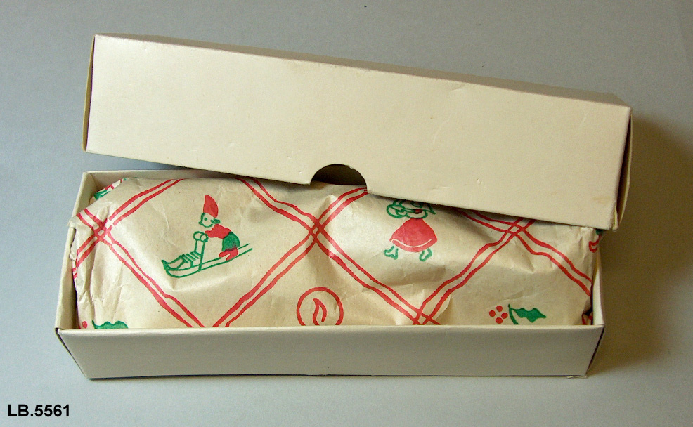 Kvit ask med to heimelaga lys pakka i julepapir. Lysa har eigne nr. i gruppering.