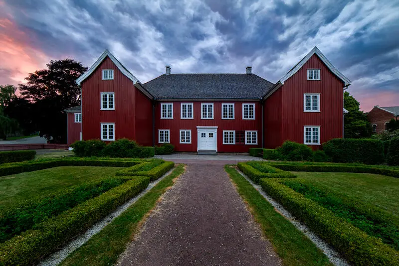 Rød bygning med hovedbygning og sidefløyer