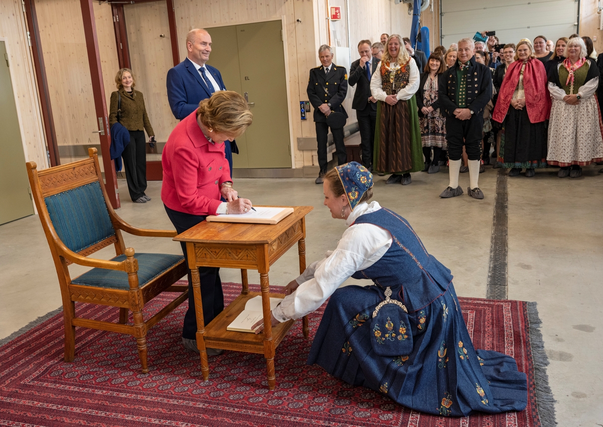 Fra åpningen av Anno bevaringssenter i Elverum, Innlandet 28. april 2022. Hennes Majestet Dronning Sonja blir mottatt av magasinforvalter Toril Skaraas Hofseth, og signerer besøksprotokollen ved inngangen til konserveringsverkstedene. Bevaringssenter for museene i gamle Hedmark. Bevaringssenteret ble åpnet av H.M. Dronningen.