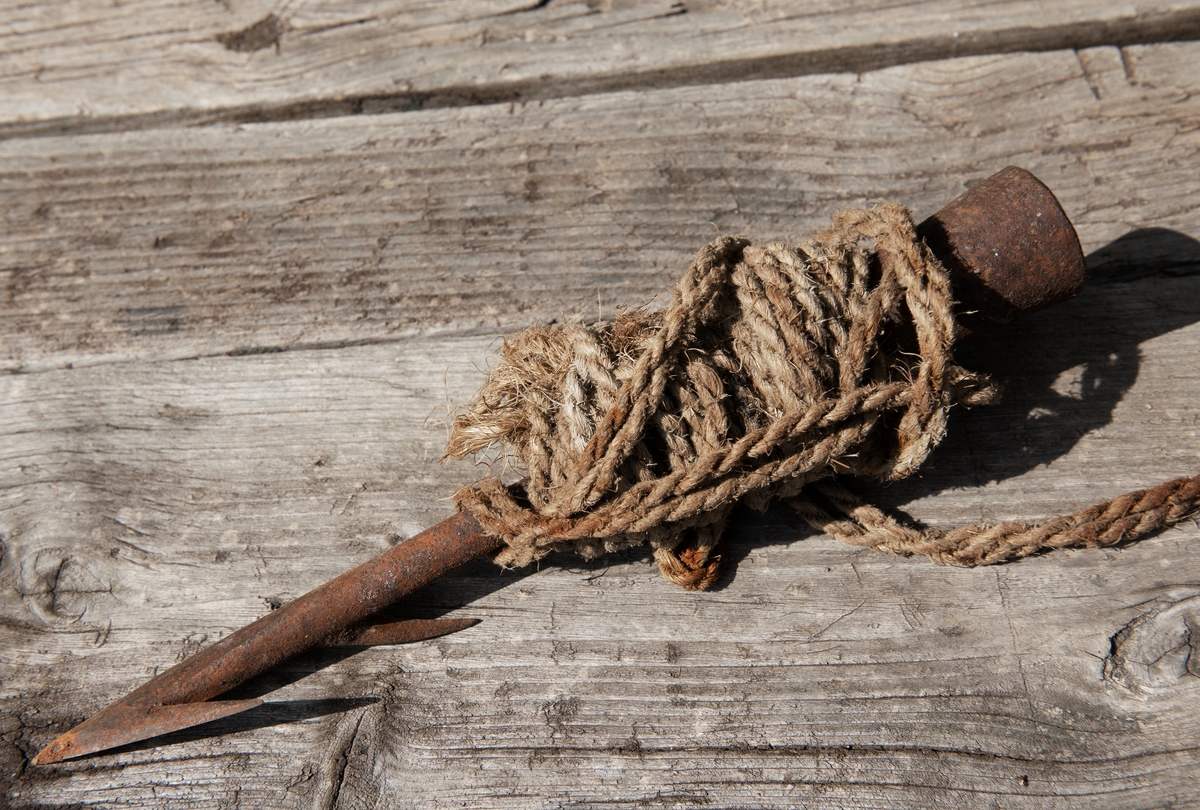 Spets av harpun, använd vid säljakt, inlindad i rep. Harpunen togs med av en estlandssvensk fiskare på flykt från Nargö till Sverige år 1943. I privat ägo.