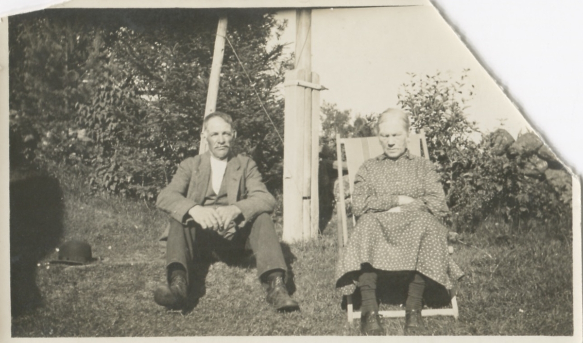 Ett gift par sitter på gräsmattan, Lilla Vommedal (nu: Streteredsvägen 25) okänt årtal. Anton Gustafsson (1873 - 1948) och hustrun Maria Gustafsson (1858 - 1944). Anton var född i Romelanda och Maria var född på gården.