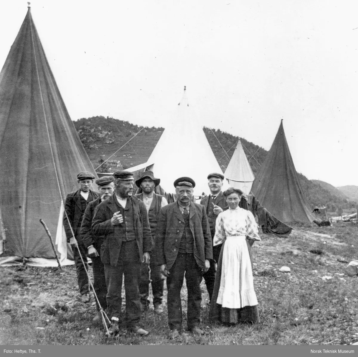 Linjearbeidere oppstilt foran teltene sammen med kokka