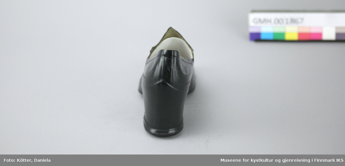 Denne kalosjen er en overtrekkssko av svart gummi. Den er foret med stoff og formen er egnet til damesko med høyere hæl.
