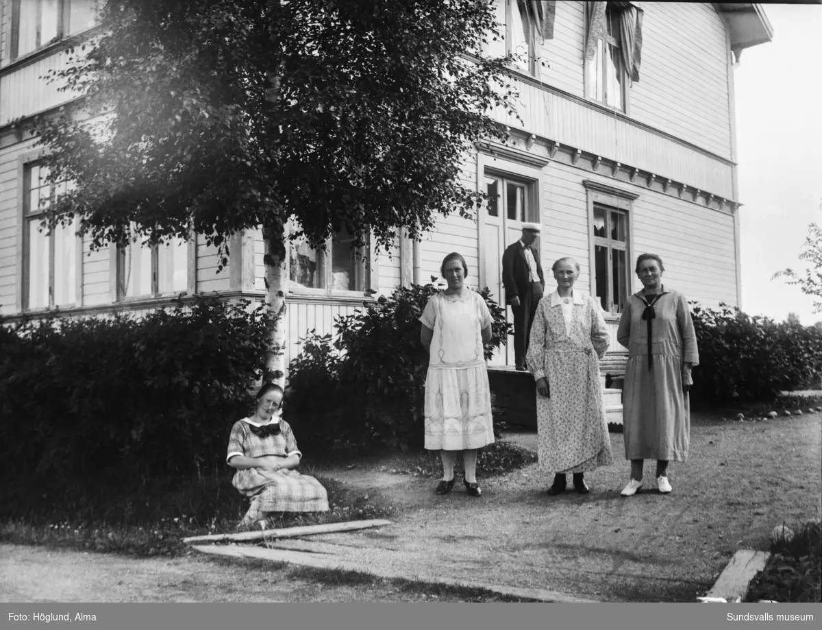 Erik Gustaf och Eva Bäckström (mitten) samt längst till vänster dottern Göta, framför bostaden i Fanbyn. De två övriga kvinnorna är oidentifierade.