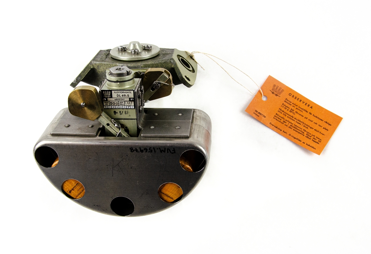 Flottörventil typ DL49-5. Tillverkad av SAAB, ritningsnummer: 6800241. Av metall, med en tillhörande orange informationsetikett om enheten.