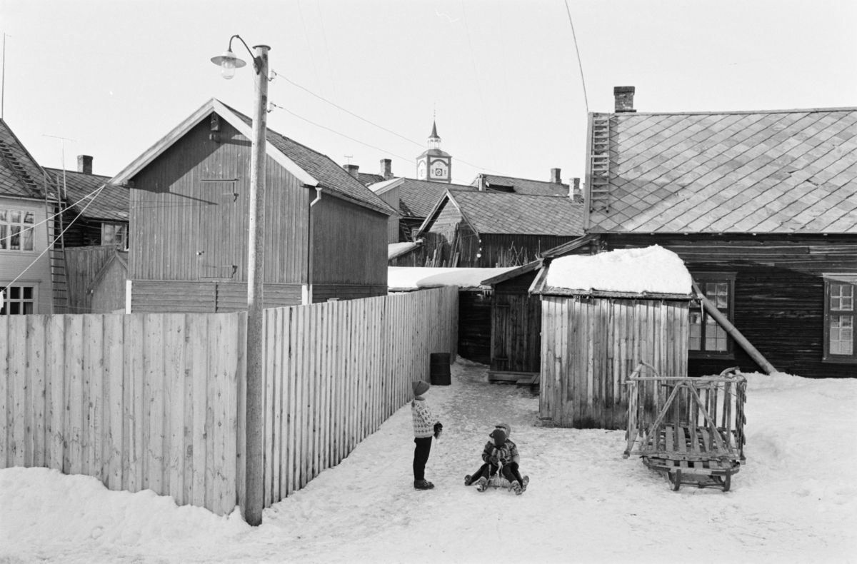 Barn leker i et gårdsrom på Røros.