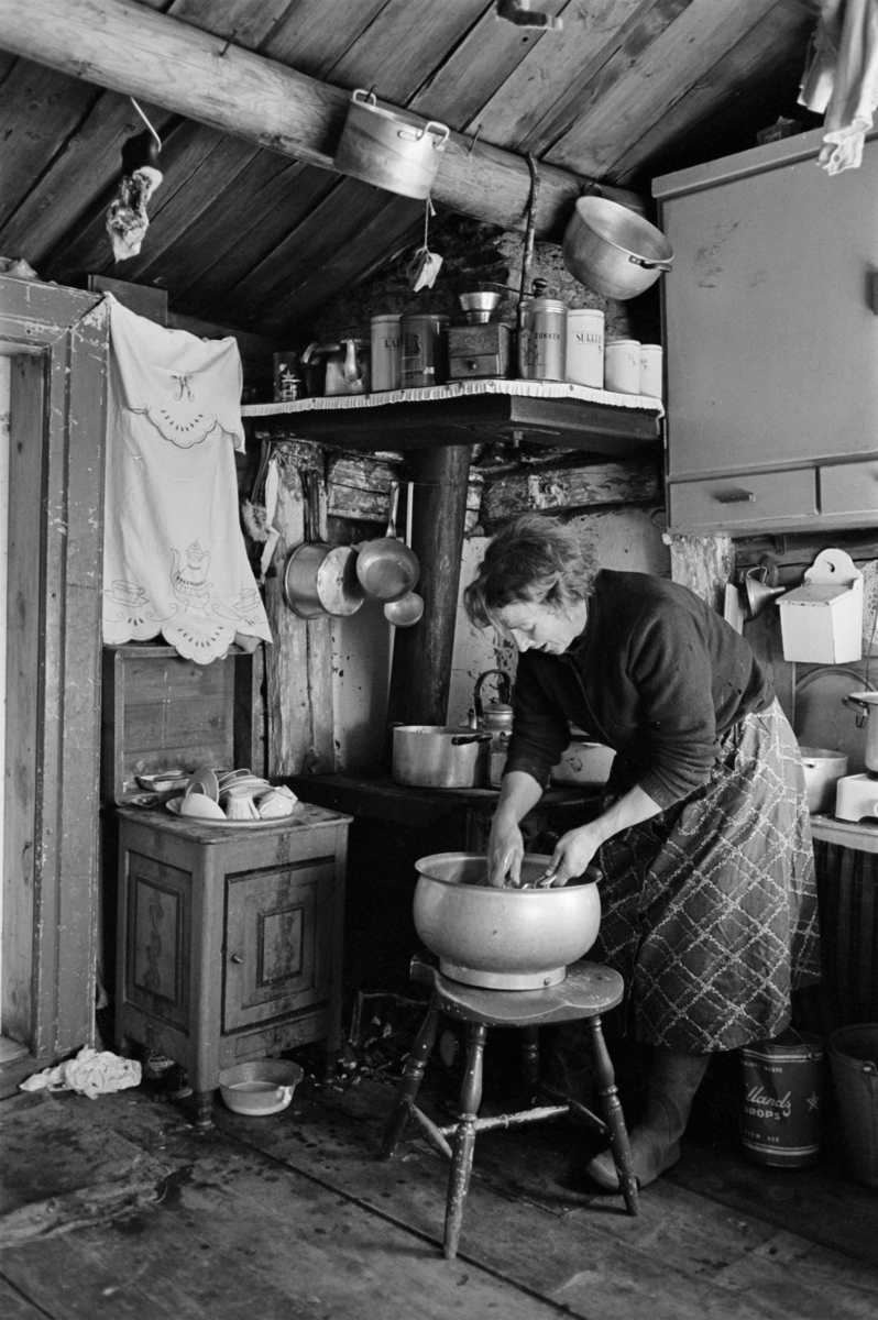 En kvinne vasker opp i et kjøkken på Røros.