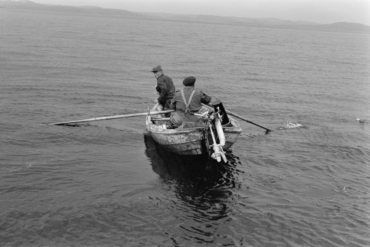 Folk i båt på garnfiske.