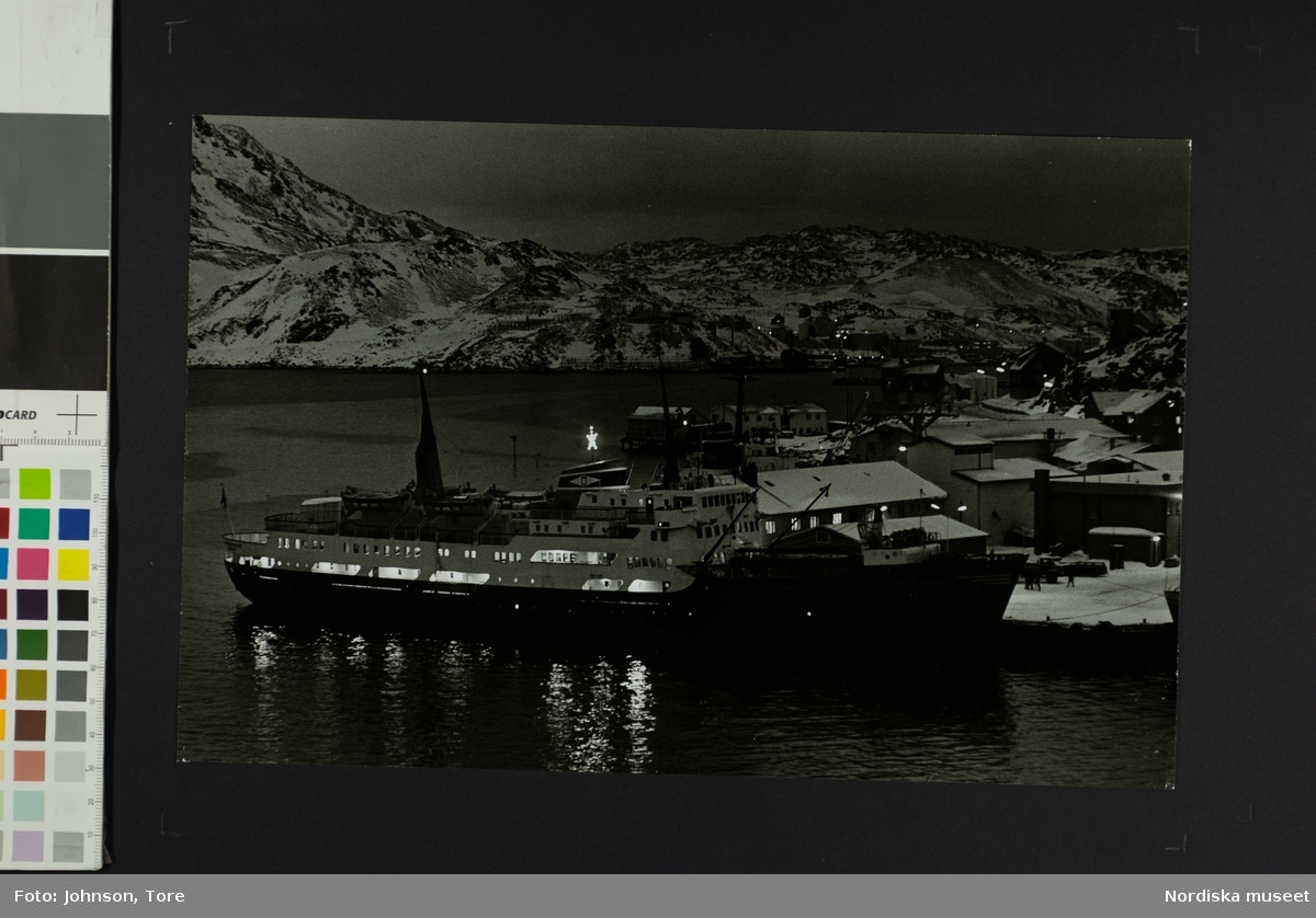 Ett fartyg ligger för ankar i en hamn. Hurtigrutt M/S anlöper Honningsvåg, Nordkap, Norge mitt på dagen i december månad.