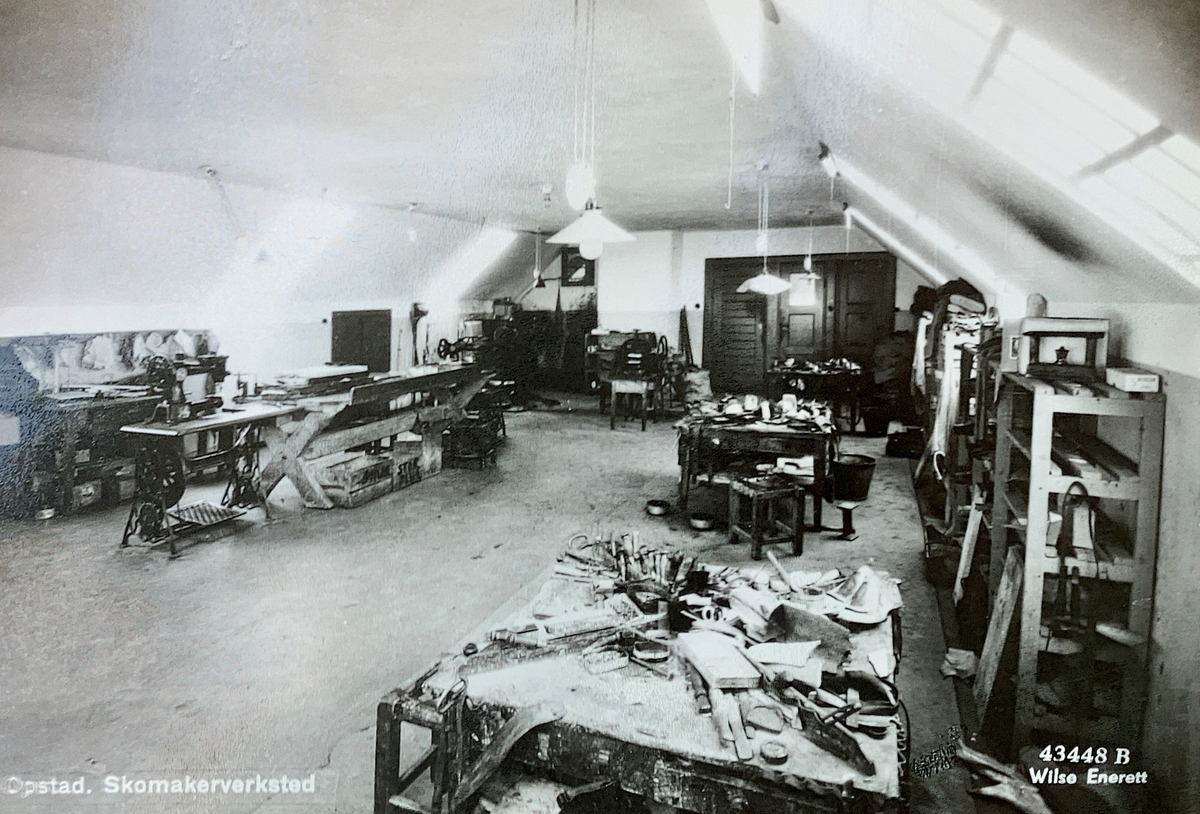 Interiørbilde fra skomakerverkstedet ved Opstad tvangsarbeidshus. Arbeidsbenker, symaskiner og hyller for verktøy.