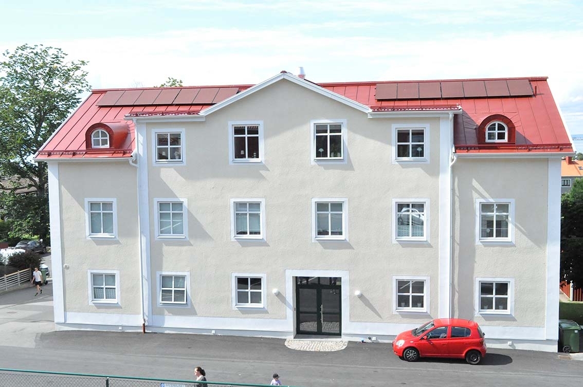 Putsat lägenhetshus i tre våningar utmed Sjögatan i Gränna.
