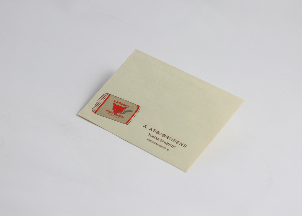 Hvit konvolutt av papir. Bilde av en pakke eventyrblanding og skriften "A. Asbjørnsens tobaksfabrik Kristiansand S" trykt nederst.