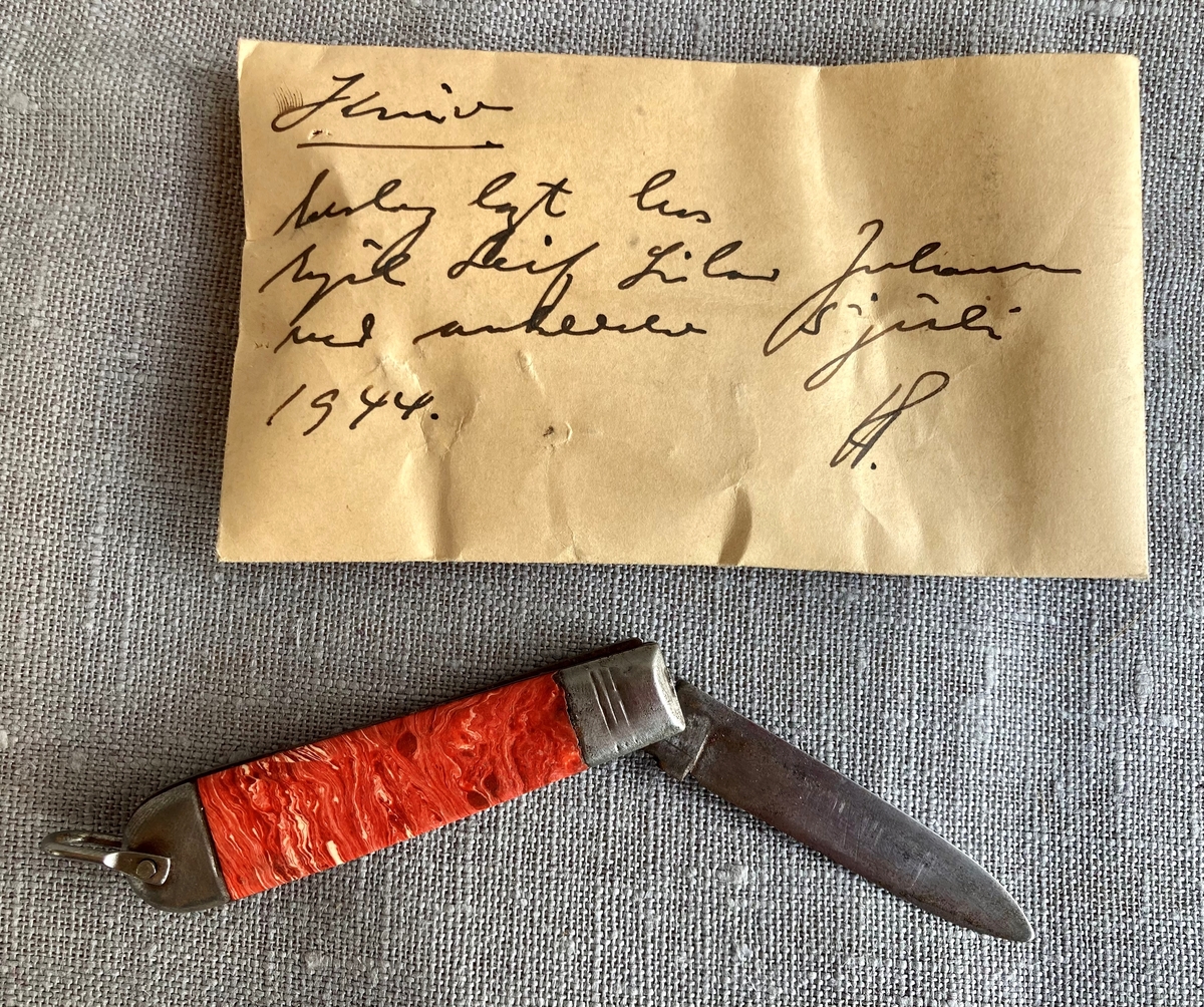 Liten sammenleggbar lommekniv med rødt marmorert skaft.