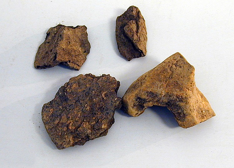Fragmenter av leirkar.
Om funnet, TGM-SM.1265-69, i helhet: Funnet i en gravhaug, 66 fot i tverrmål og 8 fot høy, bygget av jord og stein. Yngre romertid.