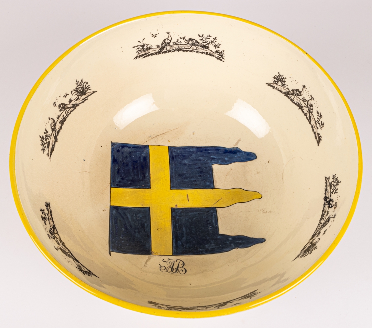 Bål, av engelsk fajans, med svensk flagga och A. B. (Anders Berggren).