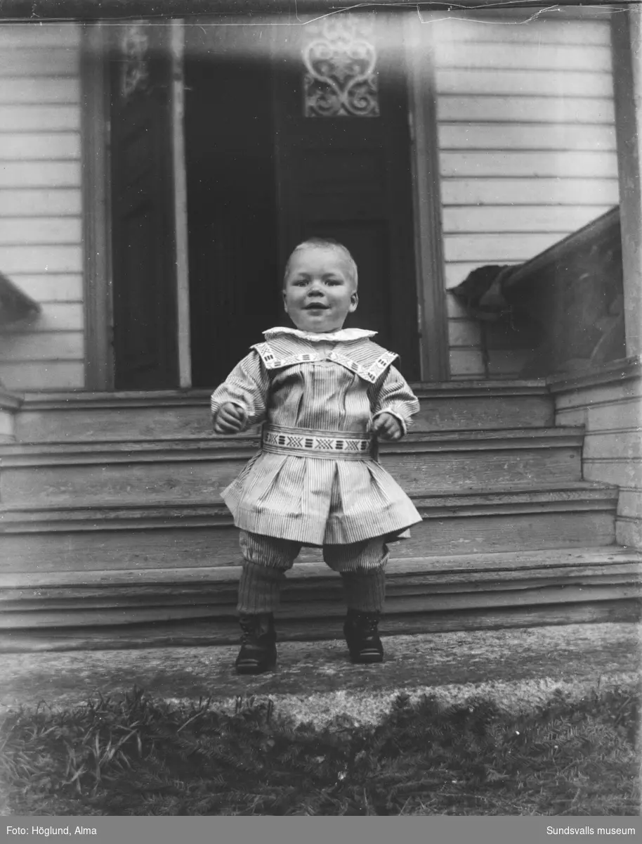 En liten pojke som står på trappen vid Per Måns-gården i Fanbyn, Stöde.