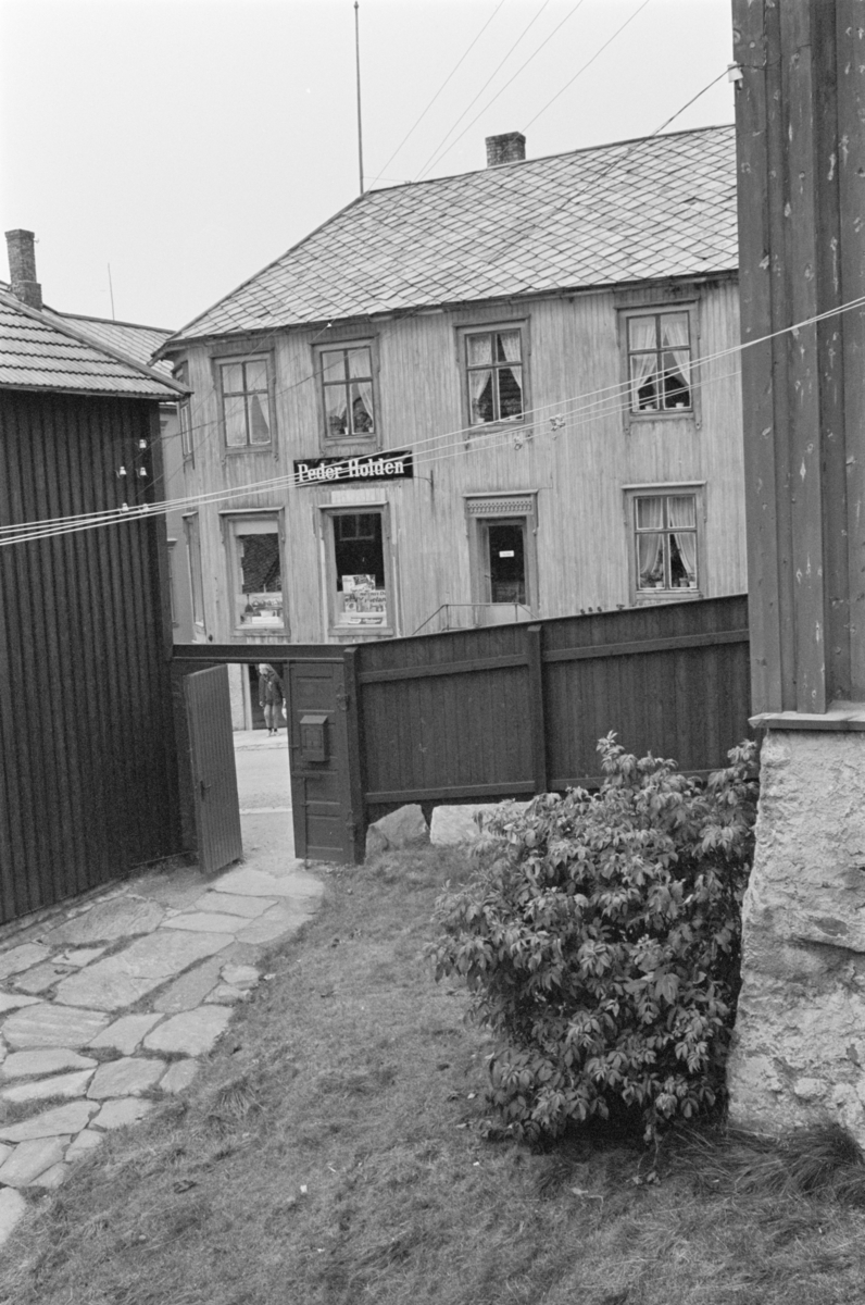 En bakgård på Røros. I bakgrunnen sees skiltet "Peder Holden". 