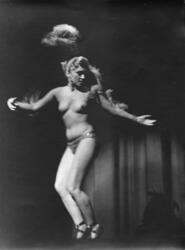Nesten naken kvinne danser på en scene. Trolig tatt i utland